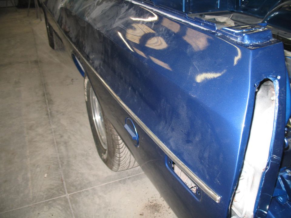 Blue pickup truck bed with chrome trim and a gas cap door. Tail light area is open