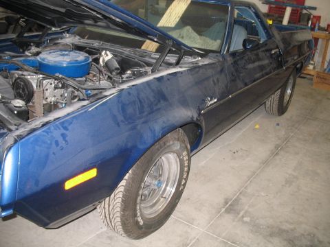 1972 Ford Ranchero - A blue 1972 Ford Ranchero is parked indoors with its hood up, revealing the engine compartment.