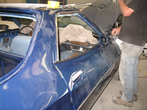 1972 Ford Ranchero - A person works on a blue vehicle that appears to be undergoing bodywork or restoration.