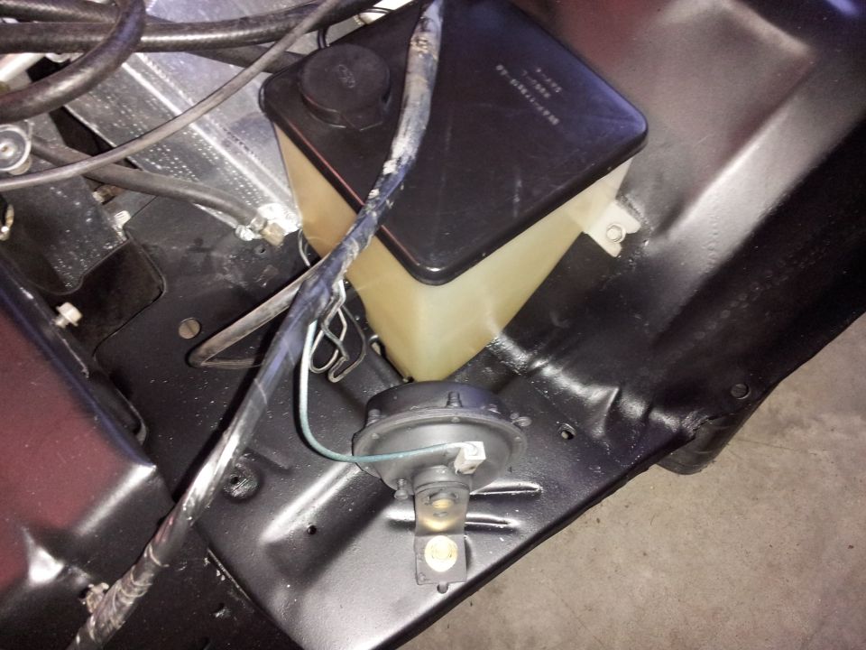 Windshield washer fluid reservoir and horn assembly in engine bay