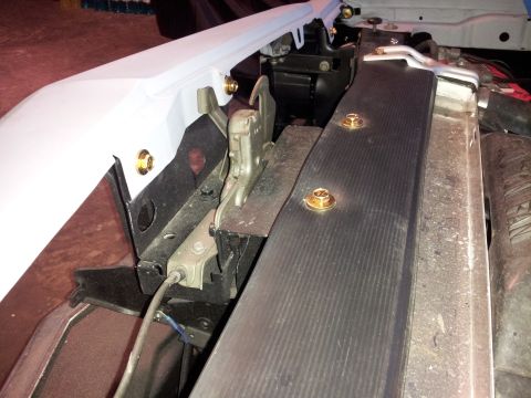 1976 Ford Ranchero - Close-up of a vehicle's hood latch mechanism, showing bolts and trim.