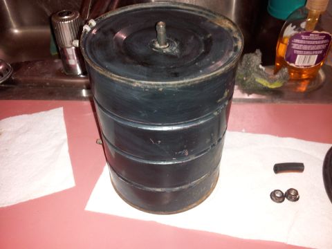 1976 Ford Ranchero - A used air cleaner assembly sits on a counter next to some small parts and a roll of paper towels.