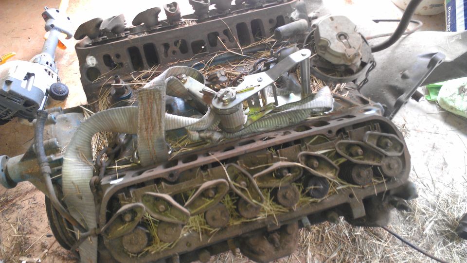 engine block with parts and straw, some straps attached