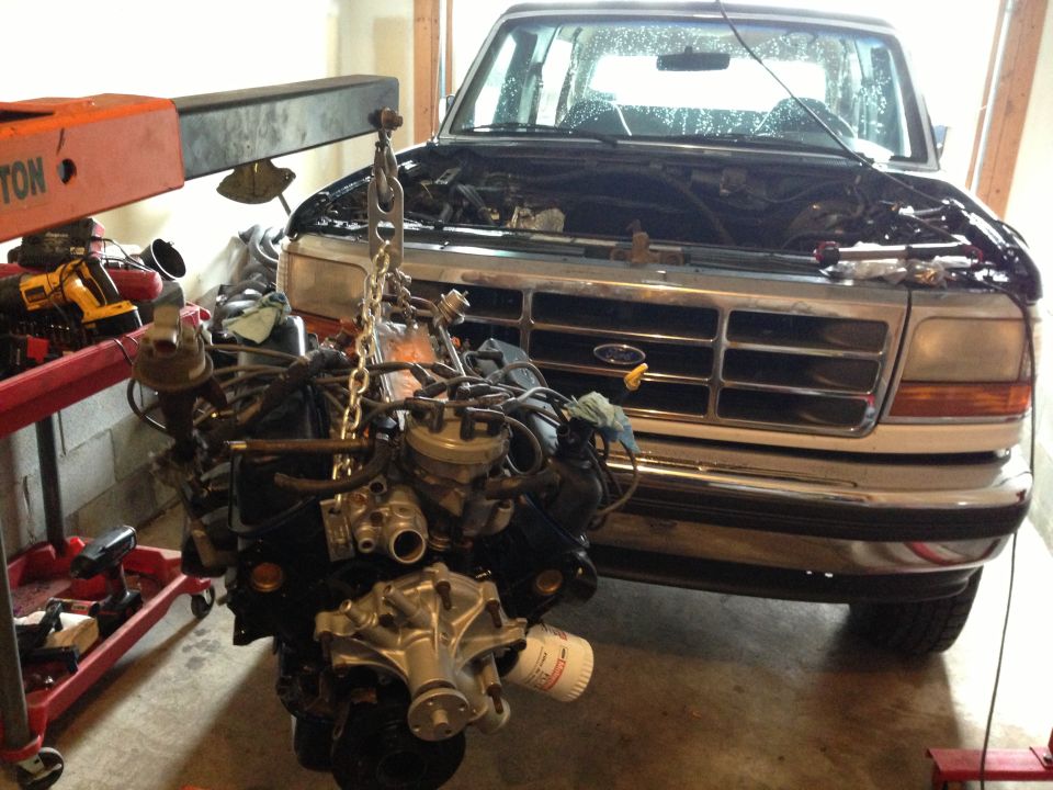 1994 Ford Bronco with engine being lifted out by an engine hoist