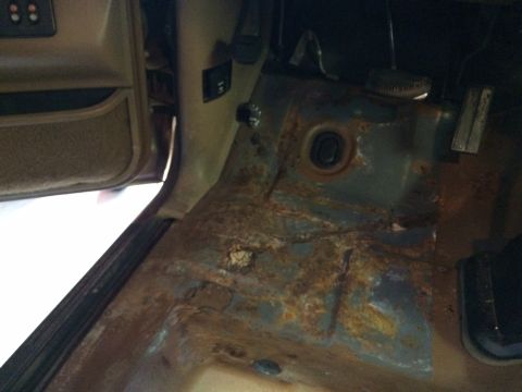 1991 Ford Bronco - Interior floor pan shows significant rust damage.