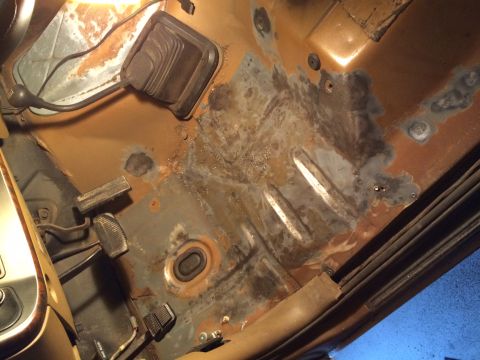 1991 Ford Bronco - The interior floor pan shows significant rust damage and some repair work.