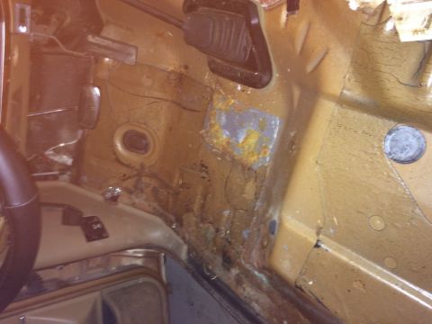 1991 Ford Bronco - The interior floor pan shows extensive rust and damage, indicating poor condition.