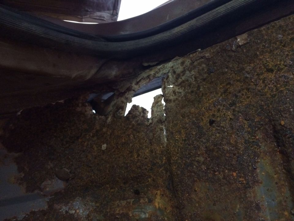 rusted out floor pan of a vehicle, showing holes and damage