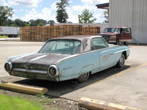 1963 Ford Thunderbird - Light blue 1963 Ford Thunderbird coupe parked in a lot with a brown roof and visible rust on the hood.