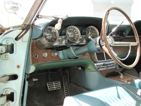 1963 Ford Thunderbird - The interior of a 1963 Ford Thunderbird features a distinctive dashboard with woodgrain accents and multiple round gauges.