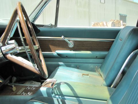 1963 Ford Thunderbird - Interior view of a 1963 Ford Thunderbird, turquoise upholstery and woodgrain accents.