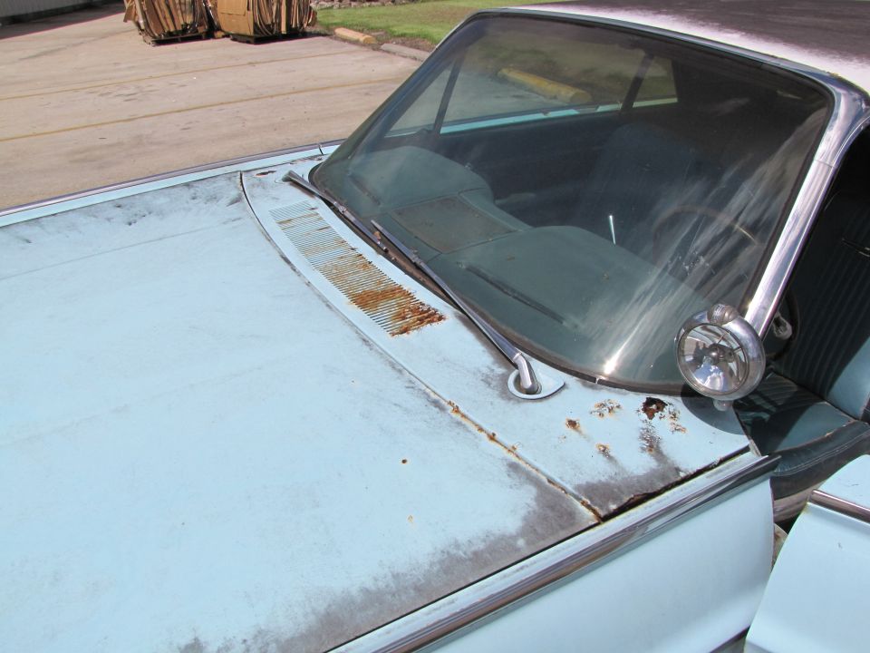 car hood and windshield, light blue paint, some rust spots, chrome trim, spotlight on fender