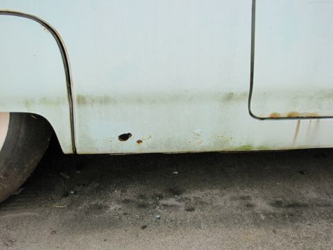 1963 Ford Thunderbird - Rust damage and a hole are visible on the bottom of a car door panel.