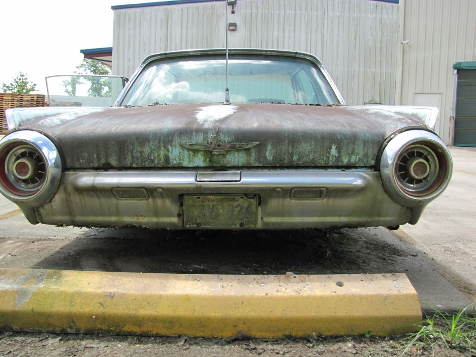 front end of a weathered 1963 Ford Thunderbird with round taillights and a bird emblem on the trunk