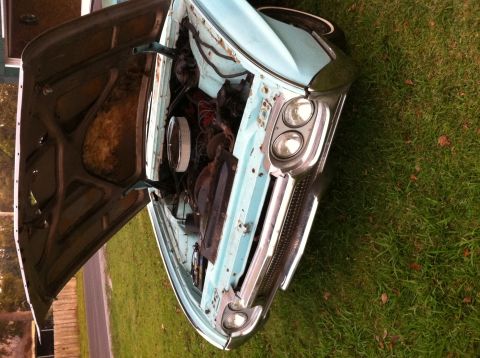 1963 Ford Thunderbird - Front view of a classic car with its hood open, revealing the engine compartment.
