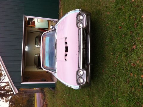 1963 Ford Thunderbird - A pink 1963 Ford Thunderbird is parked in front of a garage, with another vehicle visible inside.