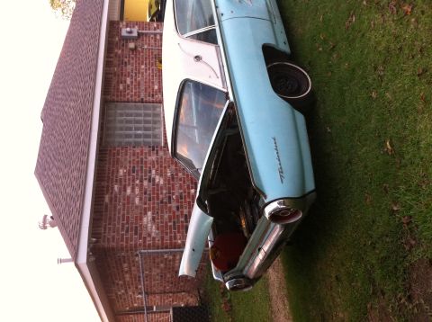 1963 Ford Thunderbird - 1963 Ford Thunderbird with its hood and trunk open, parked on a grassy lawn beside a brick house.