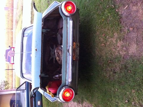 1963 Ford Thunderbird - The trunk of a vintage car is open, revealing a spare tire and a red gas can.