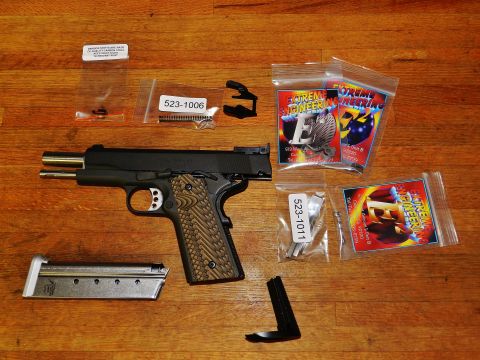 1996 Ford Bronco - A handgun, magazine, and various small parts are arranged on a wooden table.