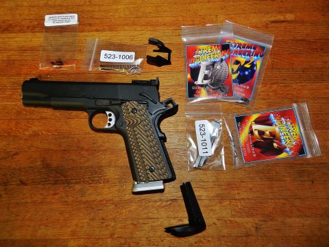 1996 Ford Bronco - A 1911 pistol and various aftermarket parts are displayed on a wooden table.