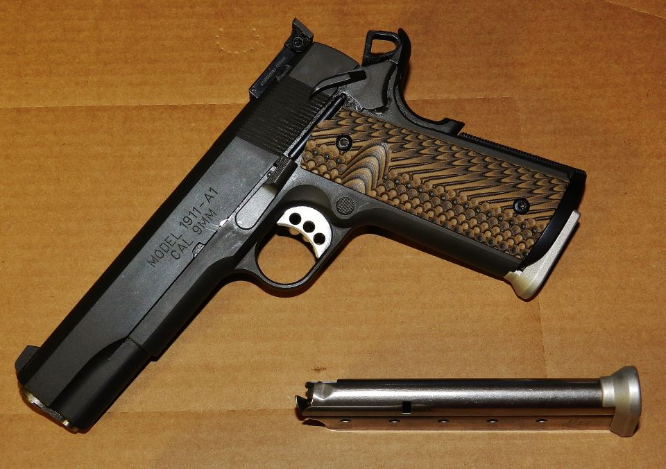 Springfield 1911-A1 pistol with textured grips and a detached magazine