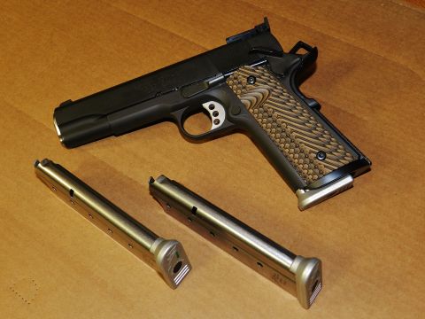1996 Ford Bronco - A handgun with two spare magazines is displayed on a wooden surface.