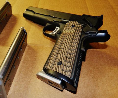 1996 Ford Bronco - Springfield Armory 1911 pistol with custom wood grips and two magazines shown on a brown surface.