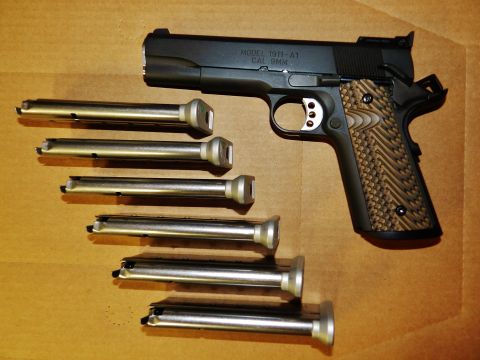 1996 Ford Bronco - A black handgun, identified as a Model 1911-A1 in 9mm, is displayed with multiple magazines.