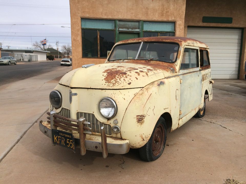 Rusty yellow van with California license plate KFR 550 parked in front of a building