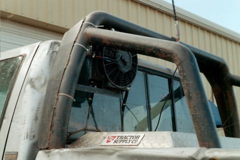 1979 Ford Bronco - A custom roll bar with an electric fan is mounted behind the cab, above a toolbox.