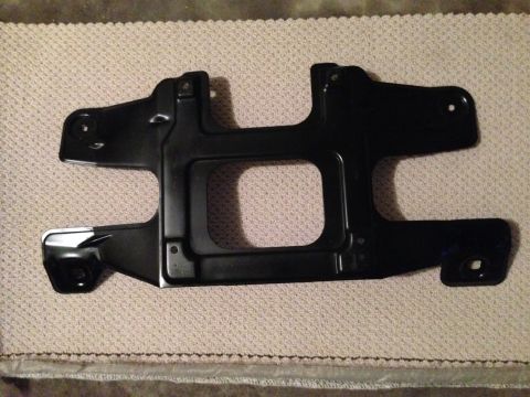 1995 Ford Bronco - A black metal bracket, likely a vehicle part, is shown from a top-down perspective on a textured mat.
