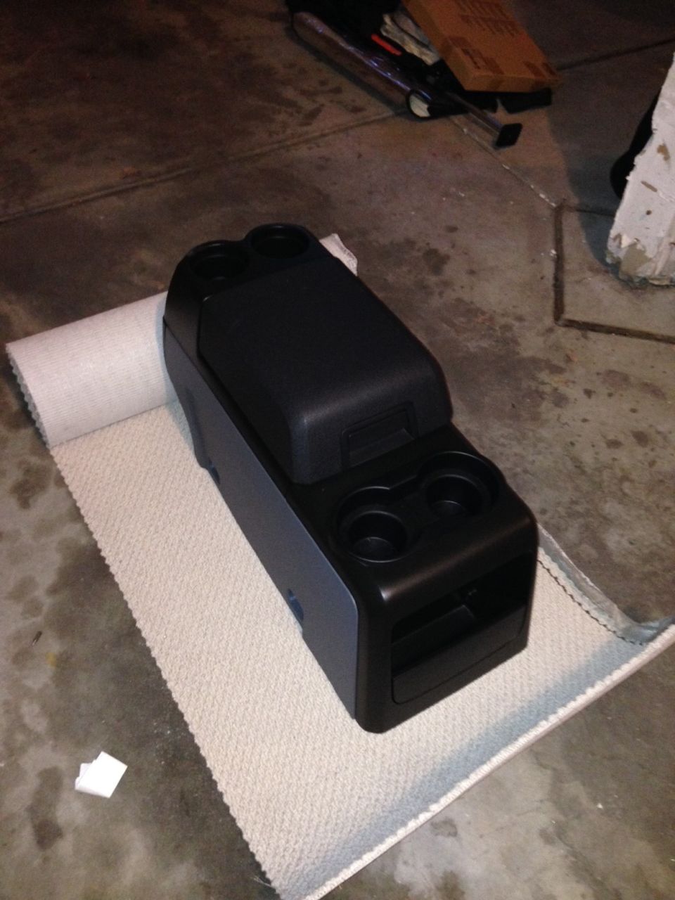 Black center console with dual cup holders and storage compartment