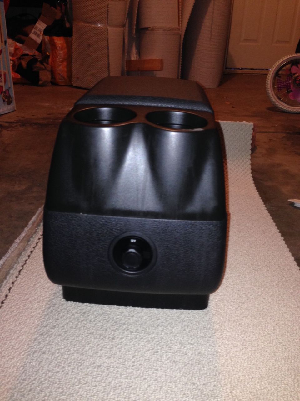 center console with two cup holders and a dial control