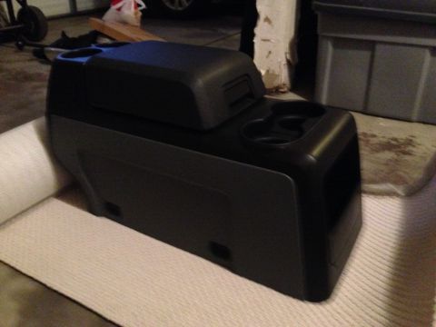 1995 Ford Bronco - This black center console features dual cup holders and a storage compartment, likely from an older SUV.