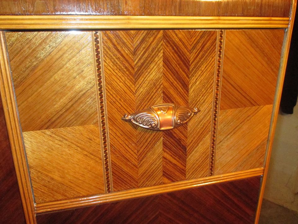 ornate wooden furniture drawer with a decorative metal handle and intricate wood inlay patterns