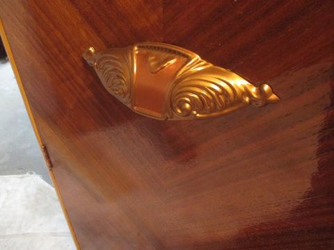 2004 Aston Martin Virage - Close-up of a decorative drawer pull with intricate scrollwork on a wooden surface.