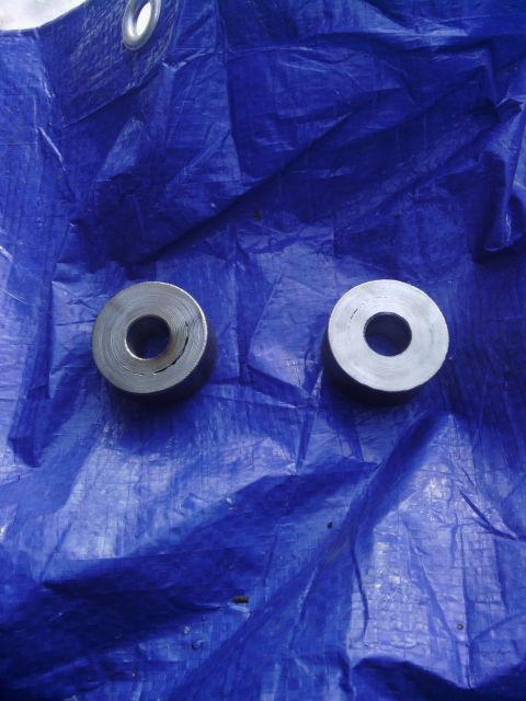 1995 GMC Safari - Two metal bushings are shown on a blue tarp, likely automotive parts.