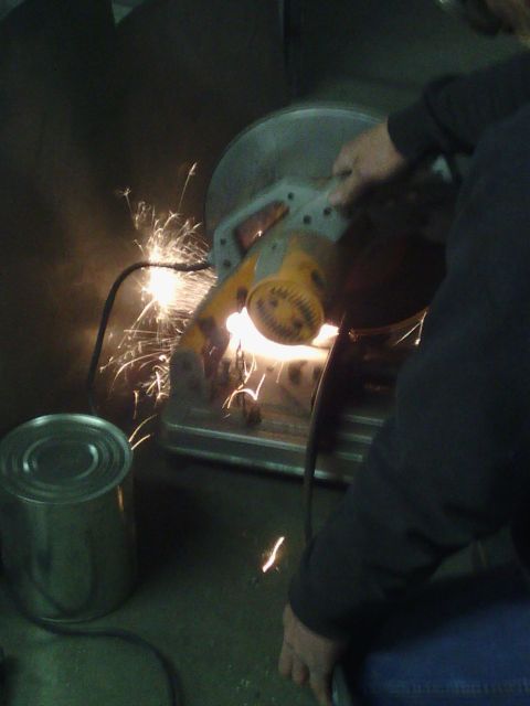 1995 GMC Safari - Metal cutting with a chop saw, sparks flying. A can is visible in the foreground.