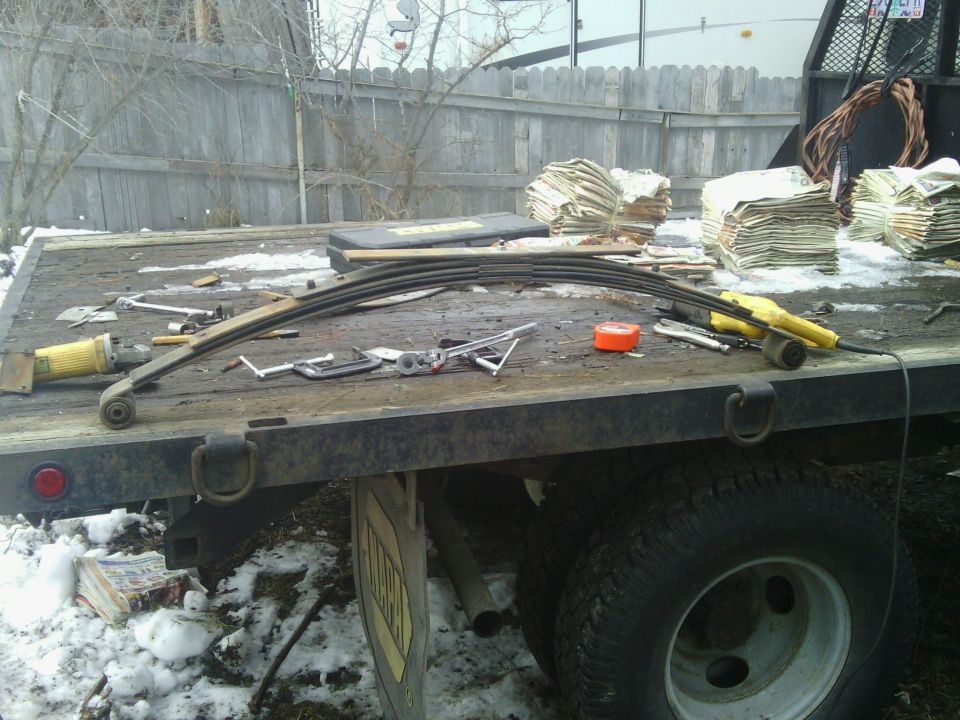 Leaf spring and tools on flatbed truck, stacks of cash in background