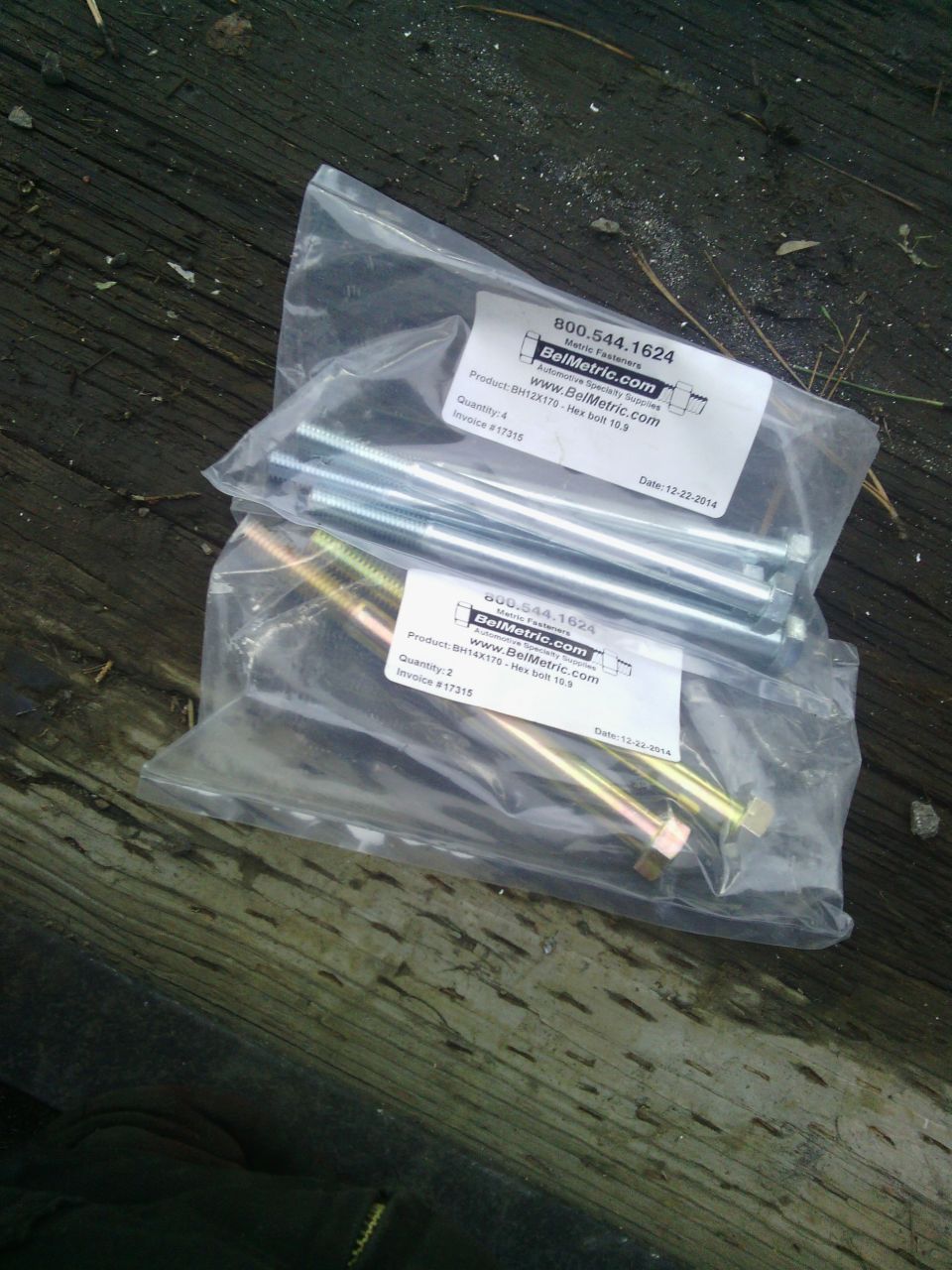two bags of bolts on a wooden surface