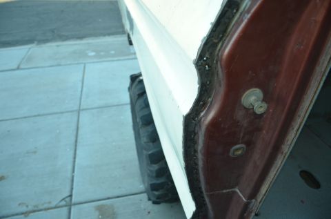 1979 Ford Bronco - Detail of the door jamb and a tire on a vehicle, with a watermark from Supermotors.net.