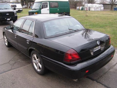 2003 Mercury Marauder - This black 2003 Mercury Marauder sedan is viewed from the rear 3/4 angle, with other vehicles present.