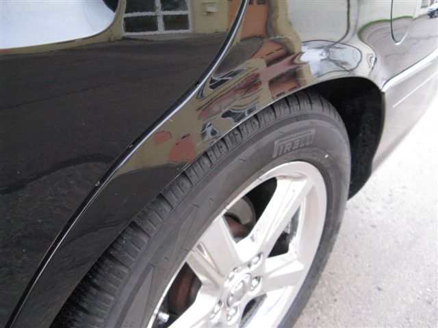 Black 2003 Mercury Marauder rear wheel and quarter panel, showing Pirelli tire