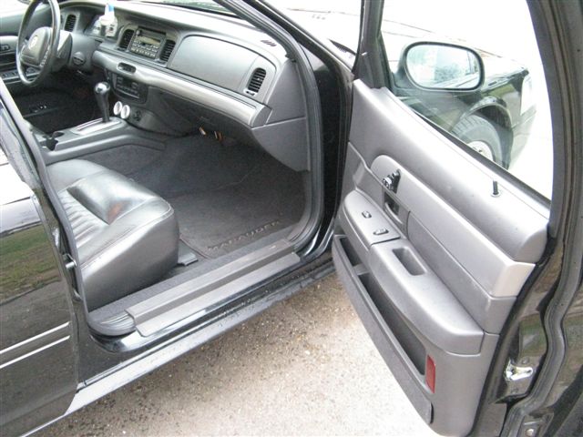 Interior shot of a black car showing the driver's seat, dashboard, and door panel. "Marauder" is visible on the floor mat