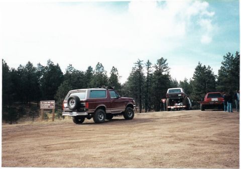 1996 Ford Bronco - A 1996 Ford Bronco is parked on a dirt road with other vehicles in the background.