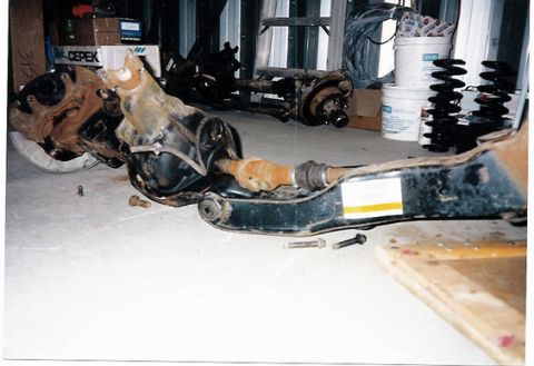 1996 Ford Bronco - Vehicle suspension parts laid out on the floor, possibly for repair or modification.