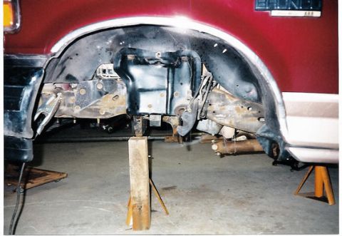 1996 Ford Bronco - The underside of a 1996 Ford Bronco is shown with the rear suspension exposed and supported by jack stands.