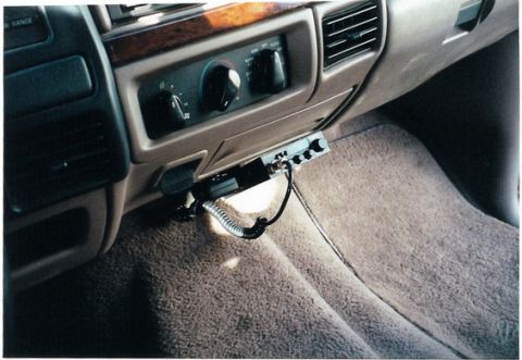 1996 Ford Bronco - A CB radio is installed in the vehicle's interior, with its coiled cord resting on the carpeted floor.