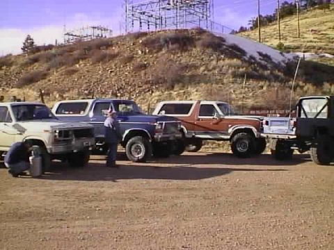 1996 Ford Bronco - A 1996 Ford Bronco is seen in a lineup of four SUVs, with a power station visible on the hill behind them.