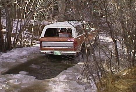 1996 Ford Bronco - 1996 Ford Bronco navigates an icy stream in a wooded area.